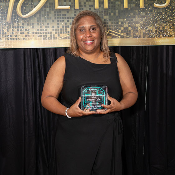 Deb Cofer, lab tech, smiles and holds award for Vaux Clinical Employee of the Year
