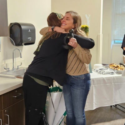 Jill Scheper hugs Annie Loughlin, RN, BSN before presenting her with the DAISY Award