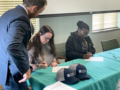 CEO and president Russell Baxley looks on as two employees sign letters of intent to take part in PATH's Cohort 10